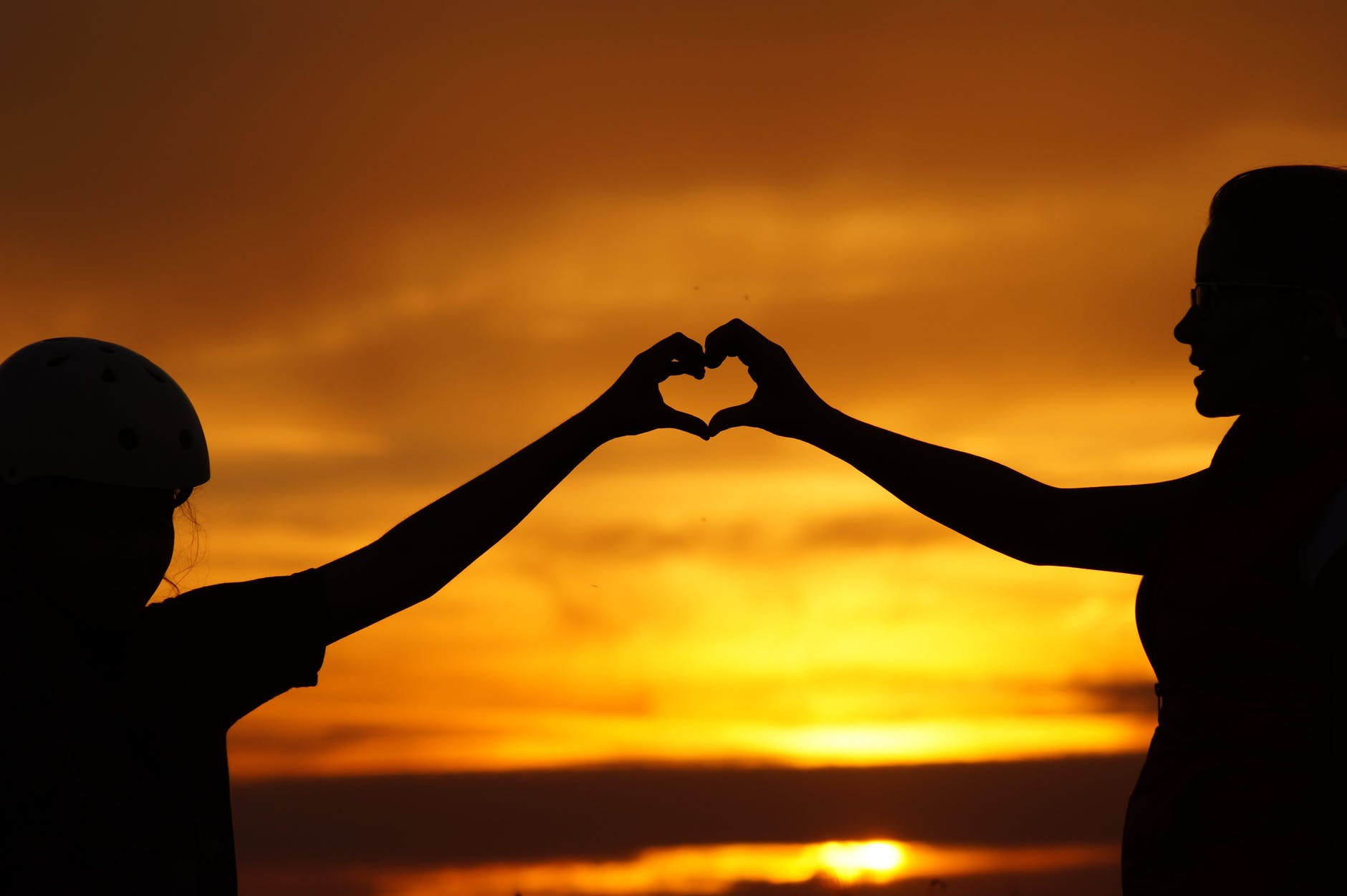 Mother and son making heart shape with their hands together